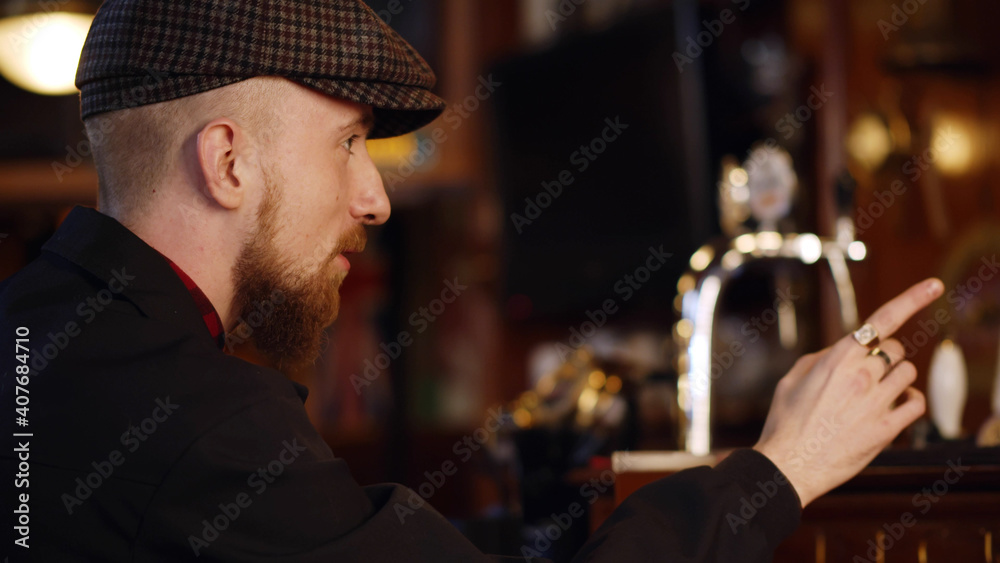 Man ordering drink sitting at counter in moder bar Man ordering drink sitting at counter in moder bar