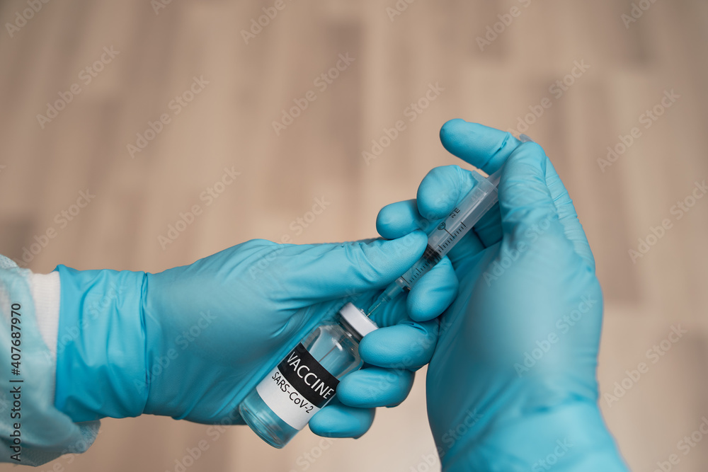 Doctors hands filling syringe with Vaccine. Doctors hands filling syringe with Vaccine.