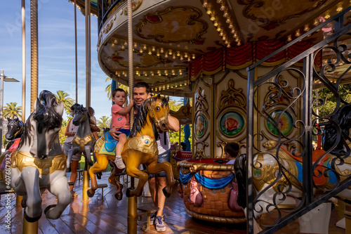 Boy with his father on top of a carousel horse in Santander.