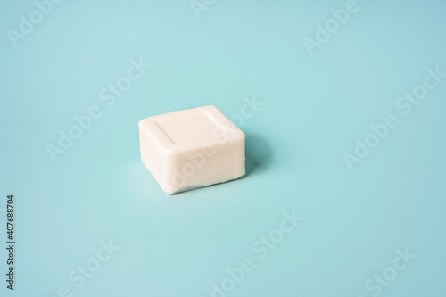 White bar of soap lying on a blue background, minimalistic concept