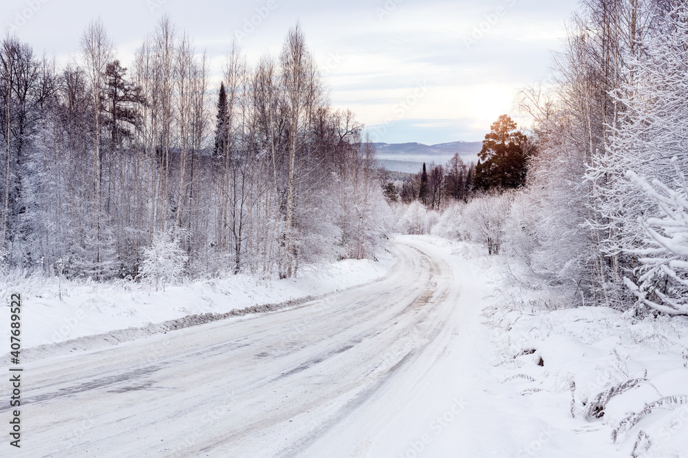 winter road in the snow-covered forest at sunset winter road in the snow-covered forest at sunset