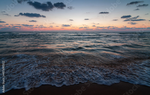 Sunset over the sandy beach of Mediterranean sea in Israel