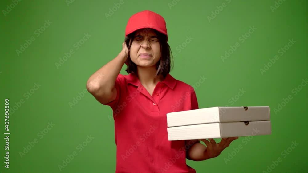 Woman holding a pizza covering both ears with hands. Frustrated expression Woman holding a pizza covering both ears with hands. Frustrated expression