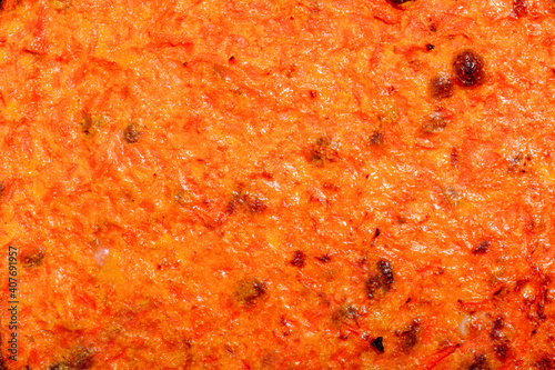 The surface of a carrot casserole with raisins close-up