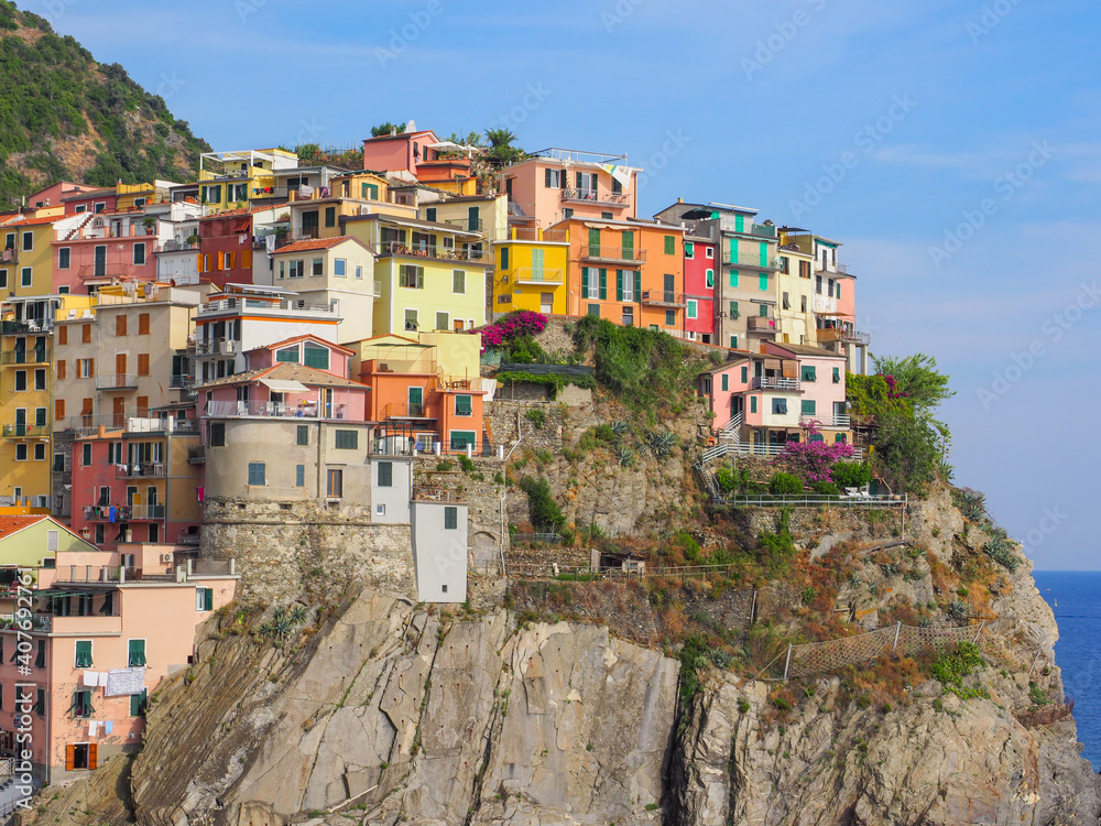 View of Manarola. Colorful old buildings on a steep cliff, close up. Traditional Italian cityscape. The Cinque Terre area is a popular tourist destination. Province La Spezia, Liguria region, Italy.
