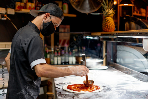 Close-up of man making pizza with tomato photo