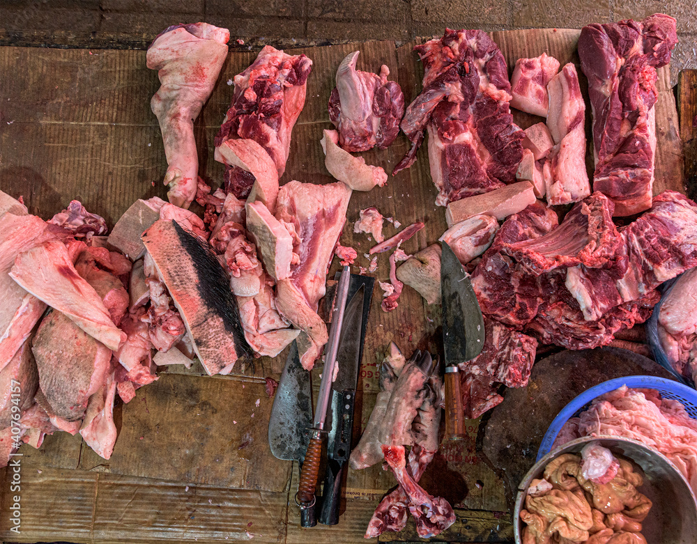 meat raw assortment and knife on the butcher's dark wooden working table. Top view.