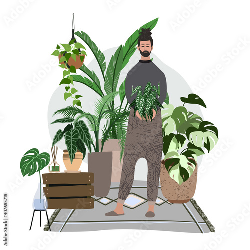 Young man standing in the cozy room with plants