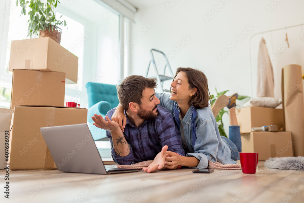 Couple searching the web for apartment renovation ideas while moving in together Couple searching the web for apartment renovation ideas while moving in together