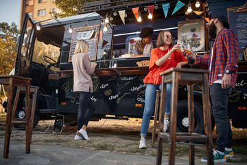 group of people enjoying in front of modified truck for mobile fast food service