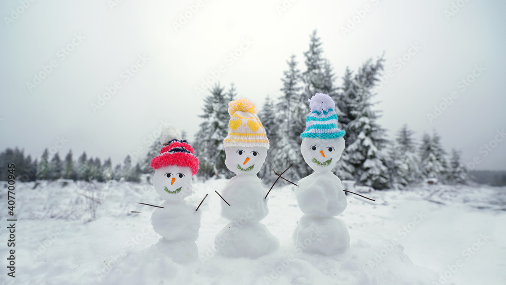 Fototapeta premium Schneemänner mit bunten Mützen