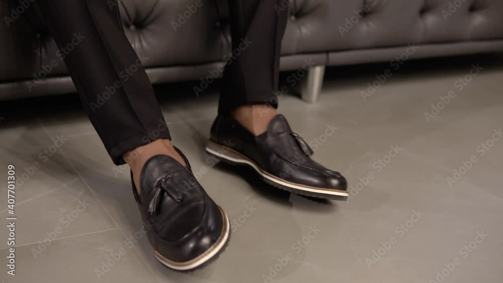 Close up of elegant man's shoes when man is sitting on a sofa Close up of elegant man's shoes when man is sitting on a sofa
