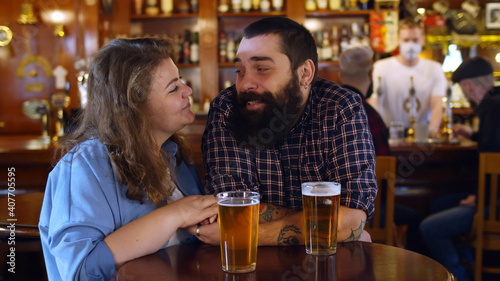 Couple in pub drinking beer, talking and having fun.