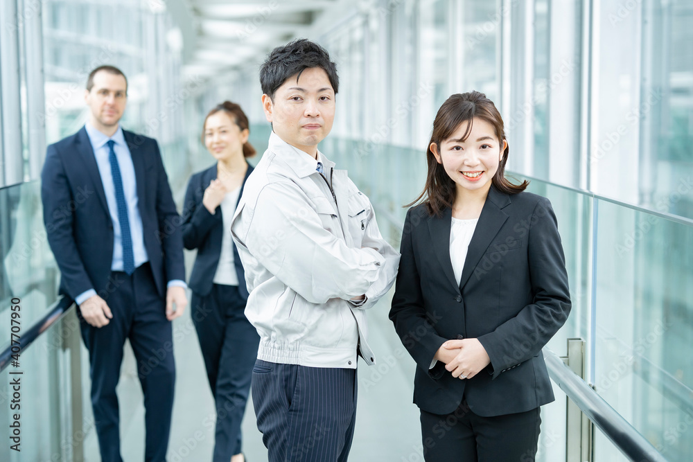 作業服姿とスーツ姿のビジネスチーム男女