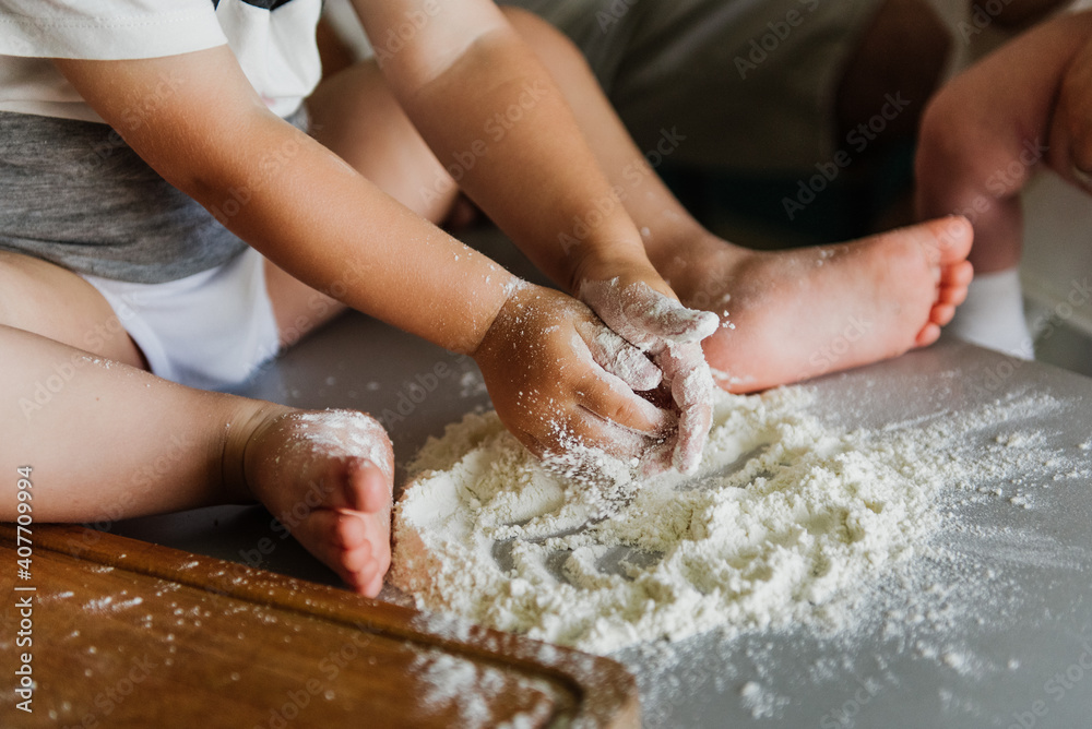 Close up of a little boy's hand in flour in the kitchen.