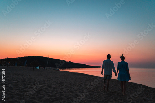 Silhouette of men and women at the beach at sunset