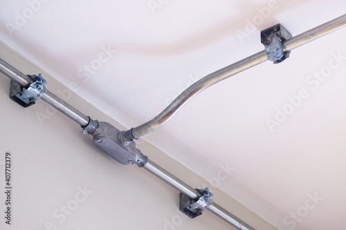 Steel conduit box to separate metal electrical pipe to different ways, installed on the wall and ceiling