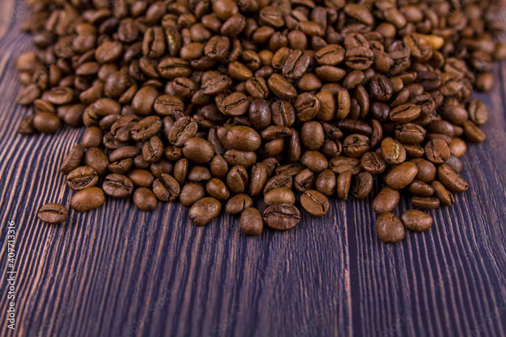 Fototapeta premium many coffee beans lie on a wooden table