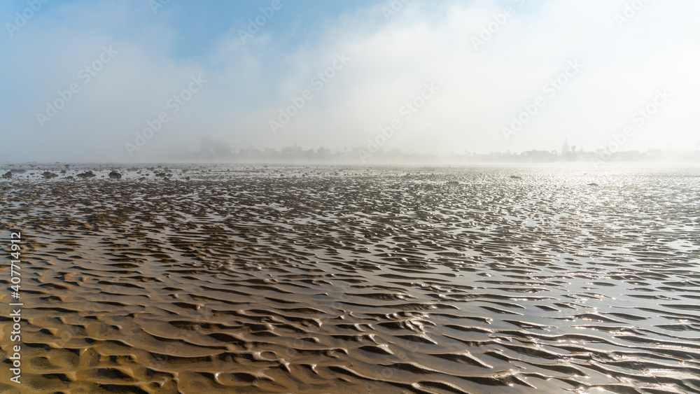 Fototapeta premium panorama landscape of fog lifting over an endless wadden sea beach at low tide