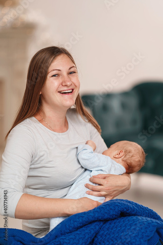 happy young woman feeds breast milk and hugs baby. a mother is breastfeeding