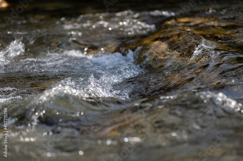 Gebirgsbach mit klarem Wasser in Bewegung