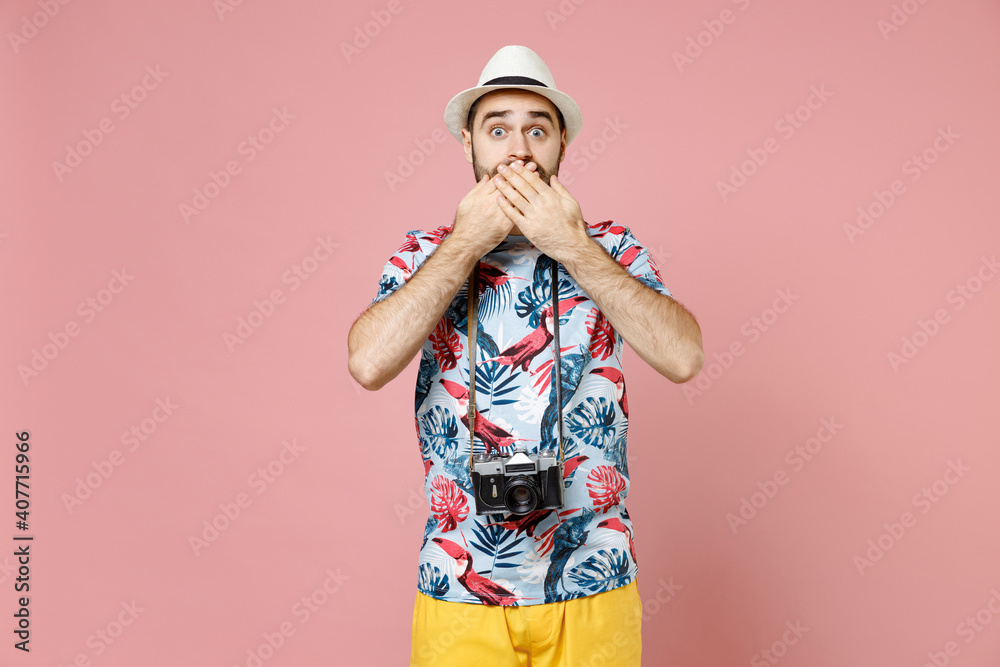 Shocked young traveler tourist man in summer casual clothes hat with photo camera covering mouth with hands isolated on pink background. Passenger traveling on weekends. Air flight journey concept. Shocked young traveler tourist man in summer casual clothes hat with photo camera covering mouth with hands isolated on pink background. Passenger traveling on weekends. Air flight journey concept.