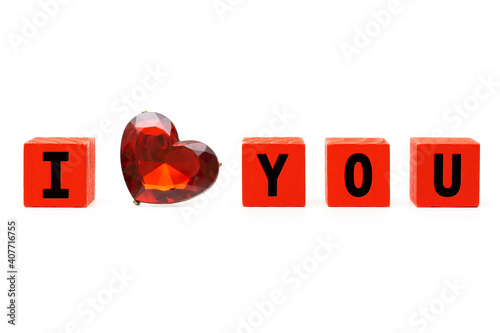 I love you phrase made of small red wooden blocks and a faceted ruby heart. Valentine's Day and love concept. photo