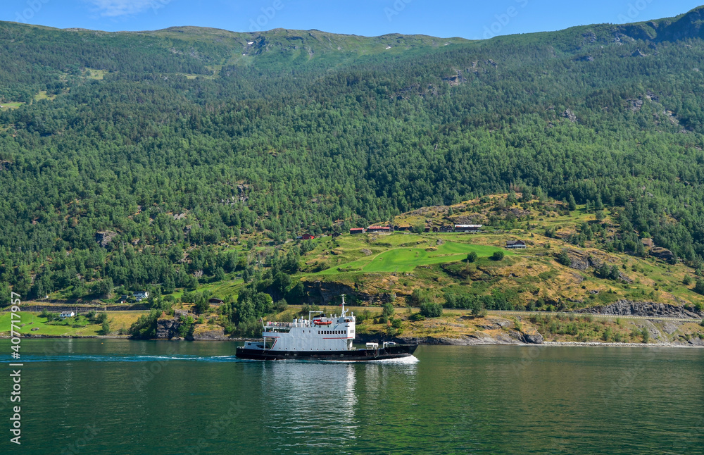Fototapeta premium Beautiful scenery with white little tourist boat crossing on one of the most beautiful fjords Sognefjord in Flam Norway Scandinavia