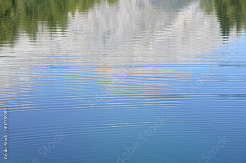 Wallpaper with water rings and a gentle reflection of forests and mountains in blue lake