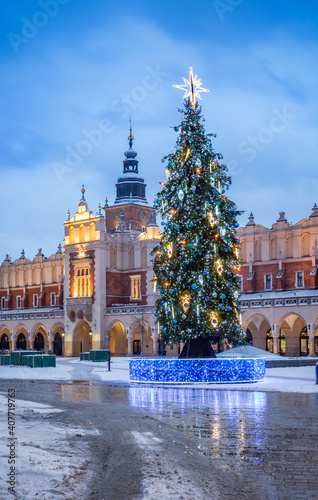 Cloth-hall (Sukiennice) in Krakow and Christmas tree on snowy winter morning, main square