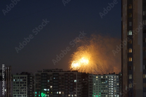 Beautiful fireworks above city roofs at nights. High quality photo