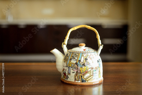 A table on which there is a mug of tea and a kettle.