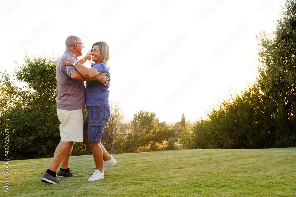 coppia di anziani balla in giardino divertendosi moltissimo