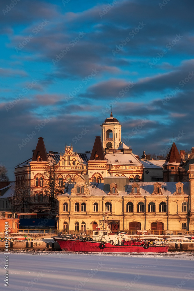 embankment with ancient beautiful buildings of the city of the middle-century city of Vyborg in Russia  in winter sunset
