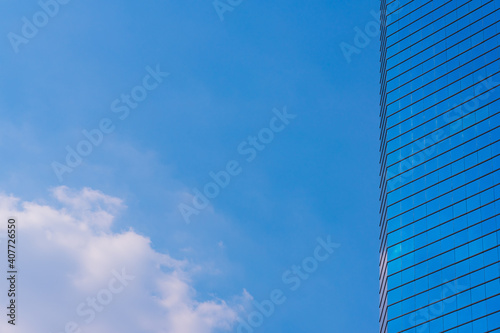 Blue sky with cloud and modern blue office building.