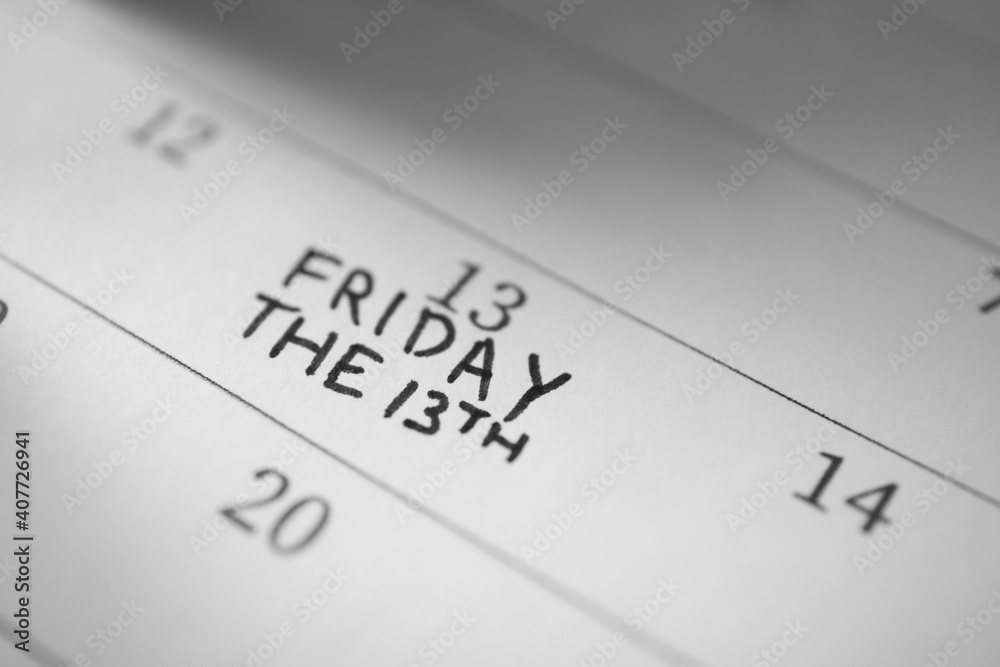Calendar page with phrase Friday The 13th, closeup. Superstition of bad luck Calendar page with phrase Friday The 13th, closeup. Superstition of bad luck