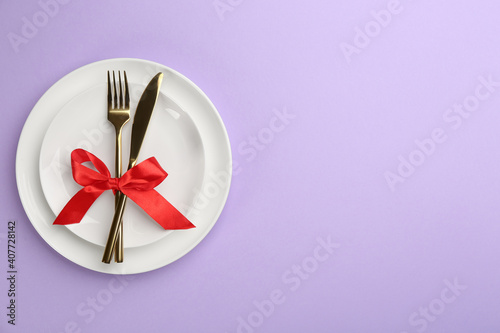 Beautiful table setting on violet background, top view with space for text. Valentine's Day dinner