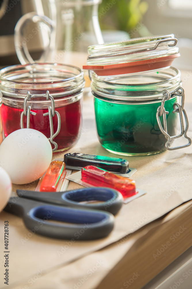 Bunte Ostereier Kaltfarben in Rot, Orange, Gelb, Blau, Grün in Verpackung auf Papier Unterlage mit Eier, Essig, Wasser, Gläser und Schere zum Färben zu Ostern Bunte Ostereier Kaltfarben in Rot, Orange, Gelb, Blau, Grün in Verpackung auf Papier Unterlage mit Eier, Essig, Wasser, Gläser und Schere zum Färben zu Ostern