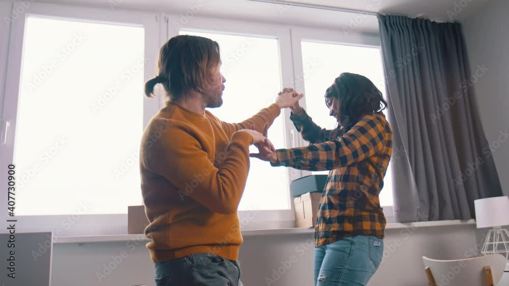 Happy young couple dancing in front of the window. High quality 4k footage Happy young couple dancing in front of the window. High quality 4k footage