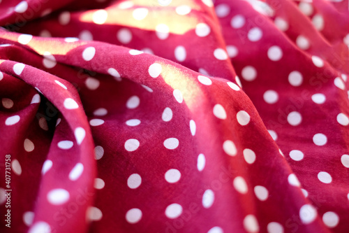 Wine red color faric with polka dots, abstract colorful background, sunlight effect photo