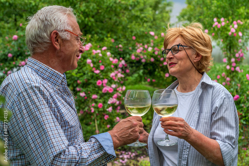 Senior man and lady holding  clinking glasses and drink  wine. Communication  friendly laughter  relationship