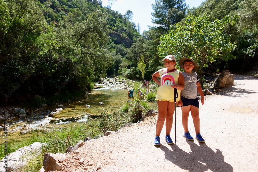 niño y niña haciendo senderimos rural junto a rio de cazorla, jaen, andalucia, españa.