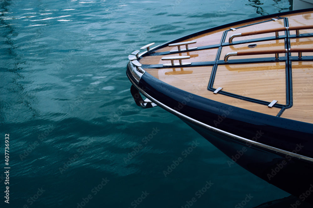 The front of a wooden yacht against the blue sea