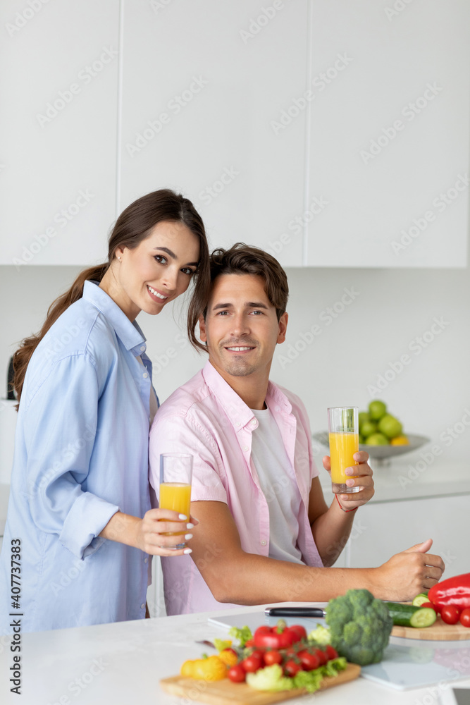 Young happy couple is enjoying healthy meal in kitchen at home.