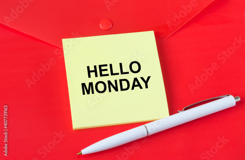 Yellow sticker with text Hello Monday on red folder