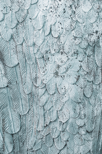 A photograph of a stucco with a fine pattern depicting a feather.
