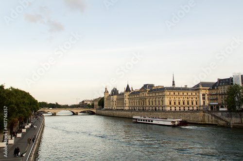 vistas del rio sena y su paseo con gente paseando barco y edificio fortaleza en el fondo photo