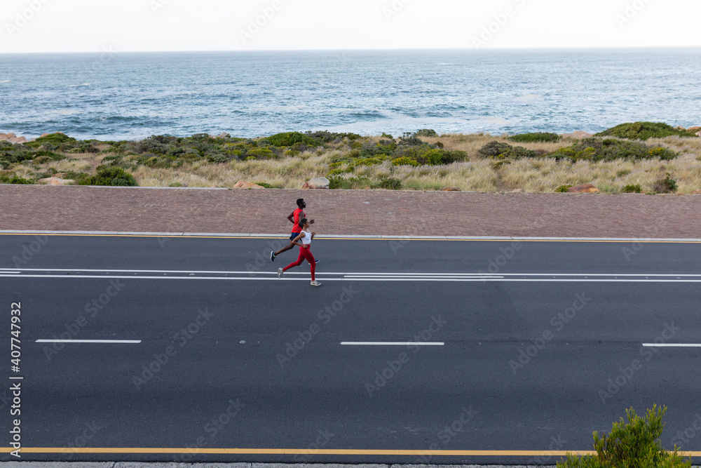 custom made wallpaper toronto digitalFit african american couple in sportswear running on a coastal road