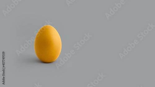 Yellow egg on grey background