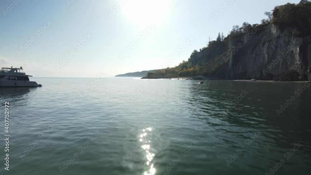 4K Aerial low flight over water past boat and towards people on a pier at Scarborough Bluffs 4K Aerial low flight over water past boat and towards people on a pier at Scarborough Bluffs